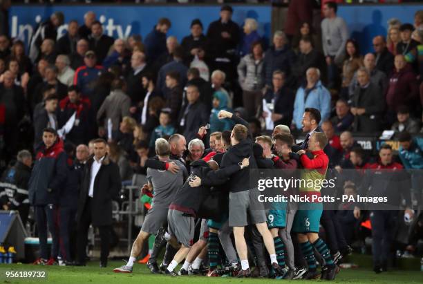 Southampton manager Mark Hughes celebrates victory with players and staff as Swansea City manager Carlos Carvalhal looks on after the Premier League...