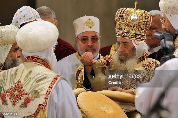 Pope Shenuda III, the head of the Egyptian Coptic Orthodox church, blesses bread to be handed out to worshippers during Christmas midnight mass,...