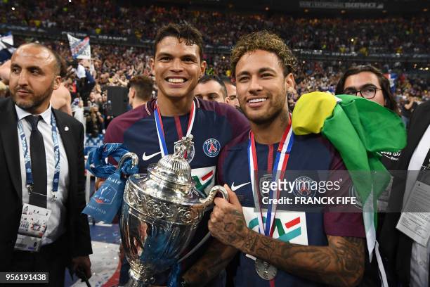 Paris Saint-Germain's Brazilian forwar Neymar Jr and Paris Saint-Germain's Brazilian defender Thiago Silva celebrate with the trophy at the end of...
