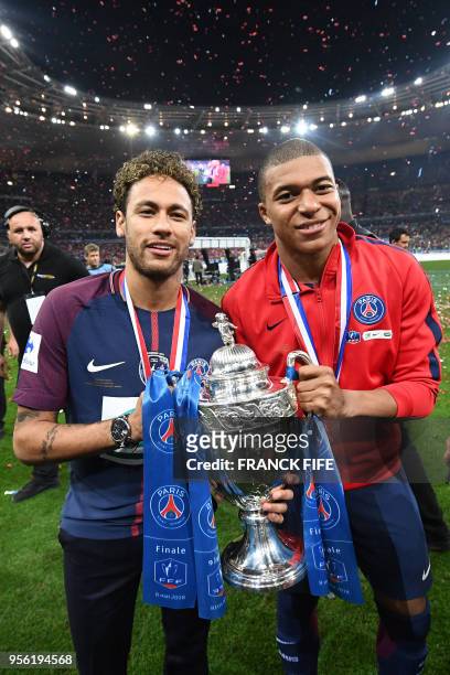 Paris Saint-Germain's Brazilian forwar Neymar Jr and Paris Saint-Germain's French forward Kylian Mbappé celebrate with the trophy at the end of the...