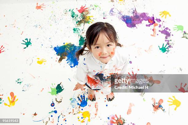 children making handprints with paint - stained shirt stock pictures, royalty-free photos & images