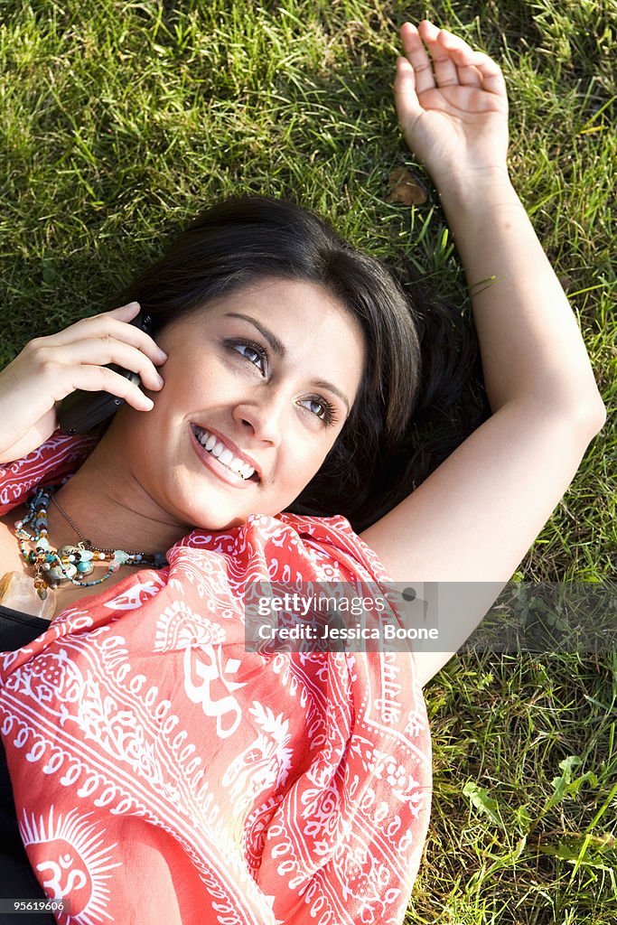 Woman lying on grass with phone