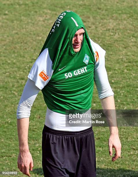 Per Mertesacker of Bremen protects his head against the heat during the Werder Bremen training session at the Al Wasl training ground on January 7,...