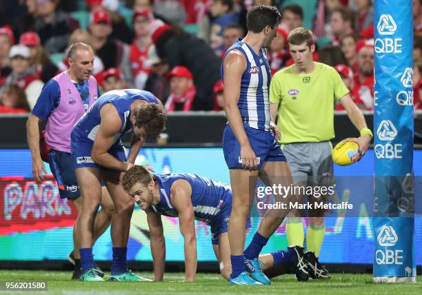 Ed Vickers-Willis of the Kangaroos is helped from the field after injuring his leg in a collision with the posts during the round seven AFL match...