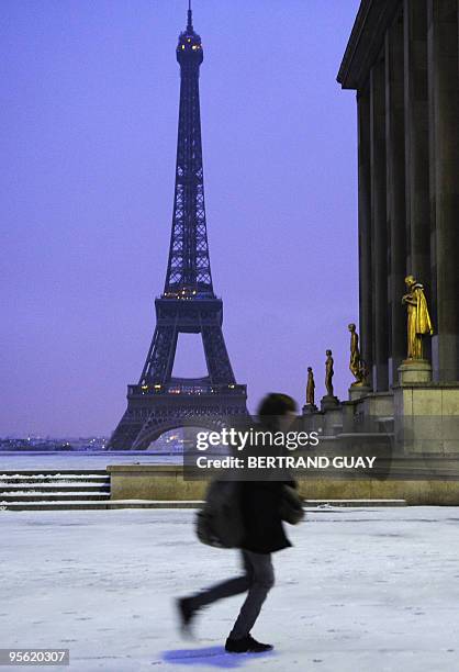 Man person walks on the snow-covered Trocadero esplanade on January 7, 2010 near the Eiffel Tower in Paris, as Europe shivered in bitterly cold...