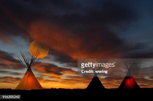 Teepee camp at sunset with full moon