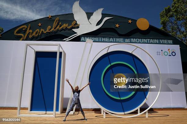An attendee poses for a photo in front of the Google I/O logo at the Google I/O 2018 Conference at Shoreline Amphitheater on May 8, 2018 in Mountain...