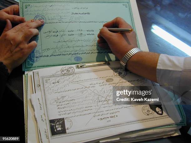 Certificates of temporary marriage filed in a registry office run by a clergyman in Tehran, October 2000. Shia Islam allows a man and woman to marry...