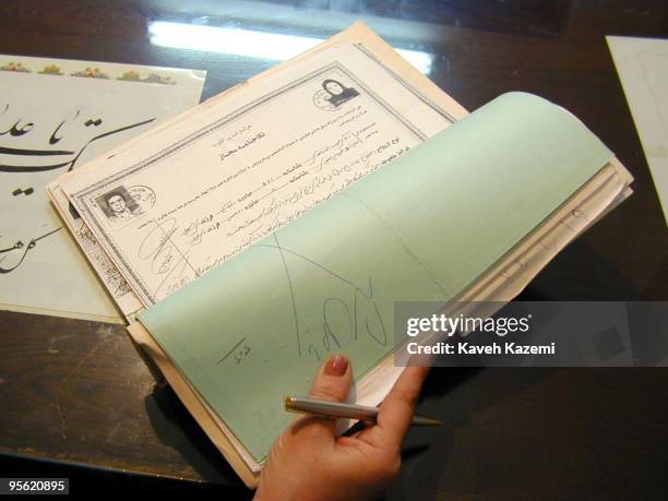 Certificates of temporary marriage filed in a registry office run by a clergyman in Tehran, October 2000. Shia Islam allows a man and woman to marry...