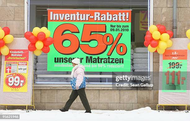 Woman walks past a mattress and bedding store offering big discounts on January 7, 2010 in Dessau, Germany. Many German retailers are offering sales...