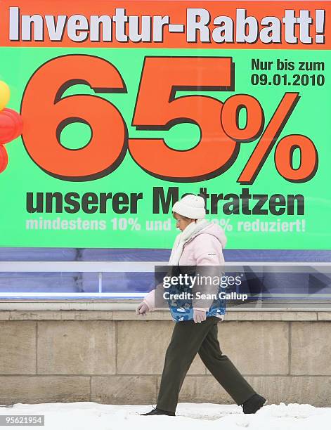 Woman walks past a mattress and bedding store offering big discounts on January 7, 2010 in Dessau, Germany. Many German retailers are offering sales...