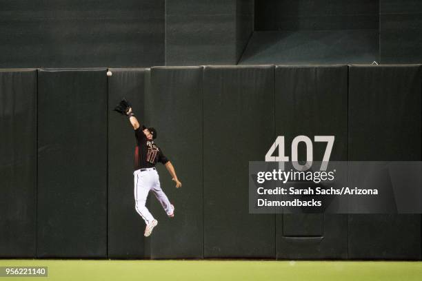 Pollock of the Arizona Diamondbacks scales the wall to catch a fly ball during a game against the Houston Astros at Chase Field on May 5, 2018 in...