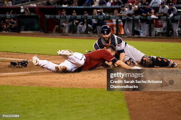 Pollock of the Arizona Diamondbacks slides into home plate against Brian McCann of the Houston Astros to score on an interference error against Alex...