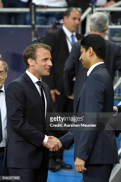 French President Emmanuel Macron shakes the hand of President of the Paris Saint-Germain Nasser Al Khelaifi as they walk to the pitch for the teams...