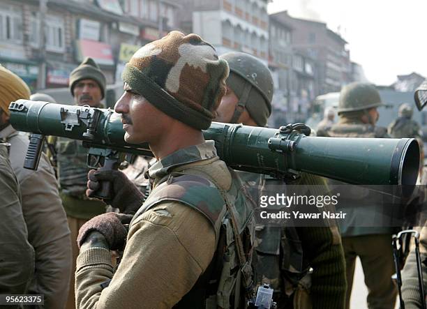 An Indian policeman carries a rocket propelled grenade launcher before storming a hotel during a gun battle between Indian police and suspected...