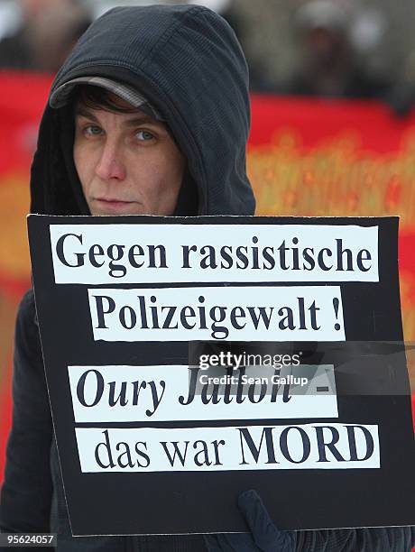 Young woman holds a sign that reads: "Against Racist Police Violence! Oury Jalloh - That Was Murder" during a demonstration marking the ruling of...