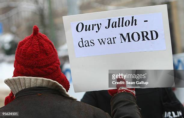 Young woman holds a sign that reads: "Oury Jalloh - That Was Murder" during a demonstration marking the ruling of Germany's Federal High Court in the...