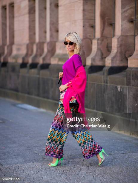 Gitta Banko wearing multi-colored trousers by Missoni, ultra violet off-shoulder cashmere sweater and pink cashmere scarf by Lamaii Cashmere, lime...