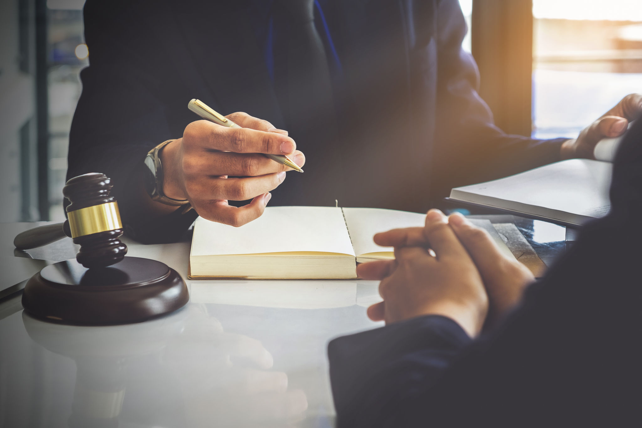 Business woman and lawyers discussing contract papers with brass scale on wooden desk in office. Law, legal services, advice, Justice concept. Business woman and lawyers discussing contract papers with brass scale on wooden desk in office. Law, legal services, advice, Justice concept.
