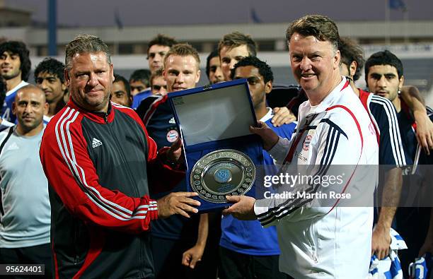 Al Nasr's head coach Frank Pagelsdorf hands over a trophy to Bayern's head coach Louis van Gaal of Bayern Muenchen during the FC Bayern Muenchen...