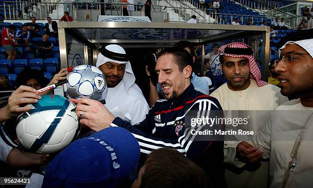 Franck Ribery of Bayern Muenchen sign autographs during the FC Bayern Muenchen training session at the Al Nasr training ground on January 7, 2010 in...