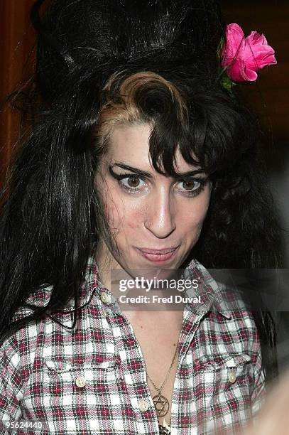 Singer Amy Winehouse accepts some bongo drums and a dvd, which she had been given by fan to sign, on her doorstep on May 27, 2008 in London, England.