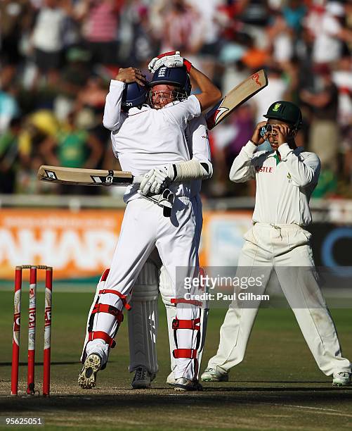 Graeme Swann of England celebrates with Graham Onions of England as Ashwell Prince of South Africa looks on after England drew the match against...