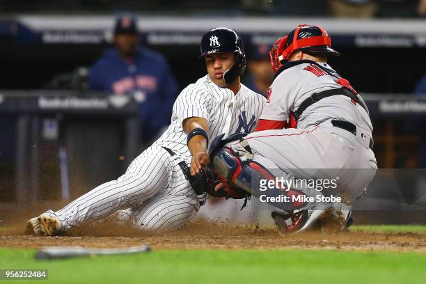 Gleyber Torres of the New York Yankees is tagged out by Christian Vazquez of the Boston Red Sox trying to score on Aaron Judge single in the seventh...