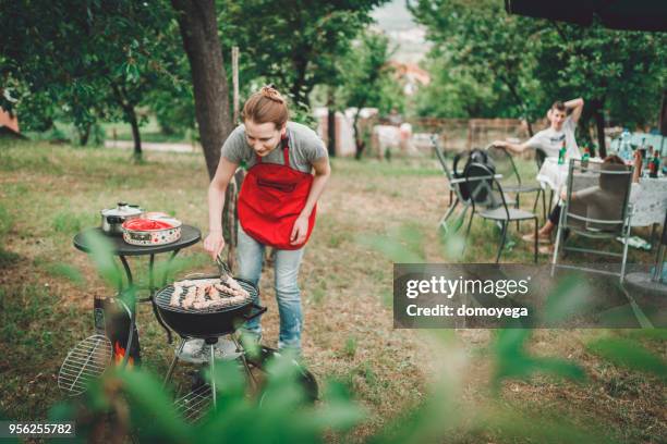 lächelnde frau eine gartenparty grillen vorbereiten - barbeque party woman stock-fotos und bilder