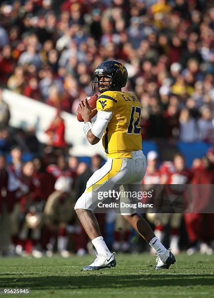 Quarterback Geno Smith of the West Virginia Mountaineers drops back to pass against the Florida State Seminoles during the Konica Minolta Gator Bowl...