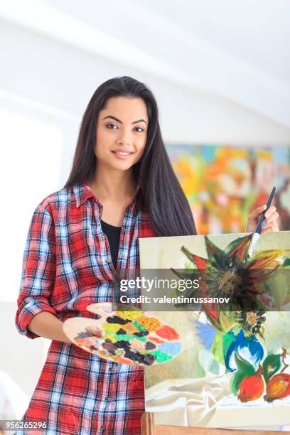 leende ung kvinna håller färgpalett och pensel - color palette bildbanksfoton och bilder