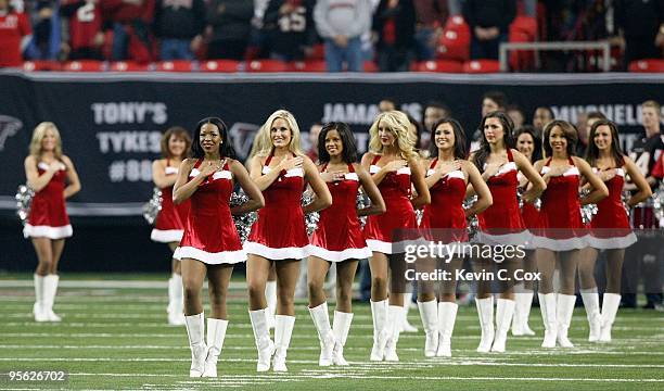 The Atlanta Falcons cheerleaders stand during the National Anthem wearing Christmas outfits before the game against the New Orleans Saints at Georgia...