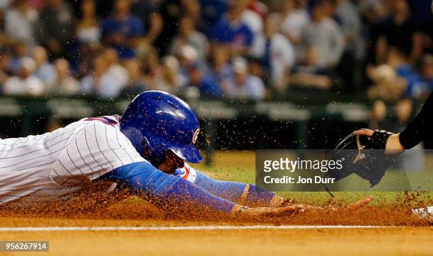 Victor Caratini of the Chicago Cubs slides safely into third base against the Miami Marlins during the sixth inning at Wrigley Field on May 8, 2018...