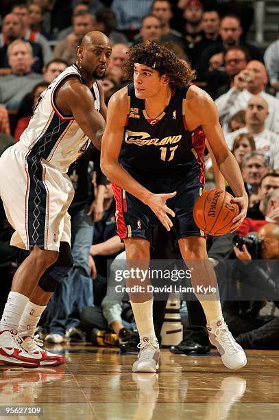 Anderson Varejao of the Cleveland Cavaliers drives the ball against Trenton Hassell of the New Jersey Nets during the game on December 15, 2009 at...