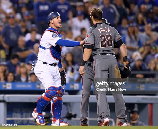 Yasmani Grandal of the Los Angeles Dodgers and third base coach Tony Perezchica get in the way of a shouting match between Steven Souza Jr. #28 of...