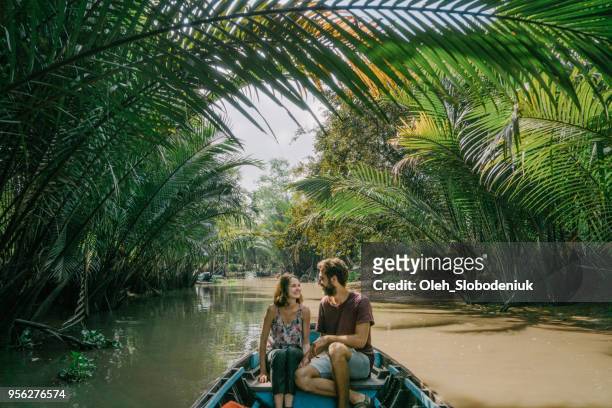 frau reitet auf boot durch das mekong-delta und schwimmenden markt - vietnam stock-fotos und bilder