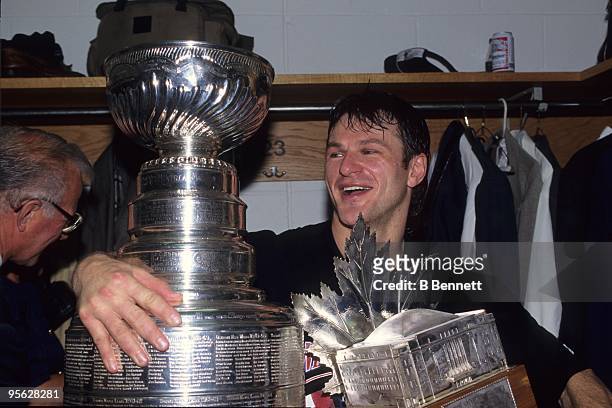 Claude Lemieux of the New Jersey Devils celebrates with the Stanley Cup and the Conn Smythe Trophy after winning 1995 Stanley Cup playoffs against...