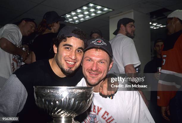 Claude Lemieux of the New Jersey Devils and Scott Gomez celebrate with the Stanley Cup Trophy after winning the 2000 Stanley Cup Finals game against...