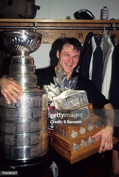 Claude Lemieux of the New Jersey Devils celebrates with the Stanley Cup and the Conn Smythe Trophy after winning 1995 Stanley Cup playoffs against...