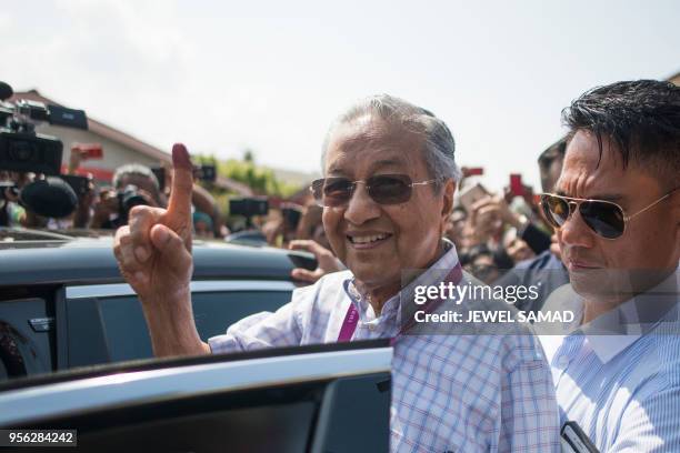 Former Malaysian prime minister and opposition party Pakatan Harapan's candidate Mahathir Mohamad shows his inked finger to supporters as he leaves a...