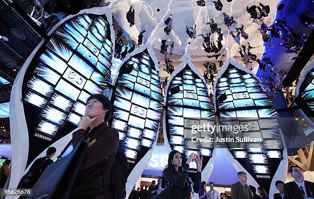 Attendees look at a display of Samsung 3-D televisons in a room with a mirrored ceiling at the 2010 International Consumer Electronics Show at the...