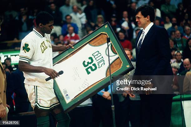 Robert Parish of the Boston Celtics presents Kevin McHale with a