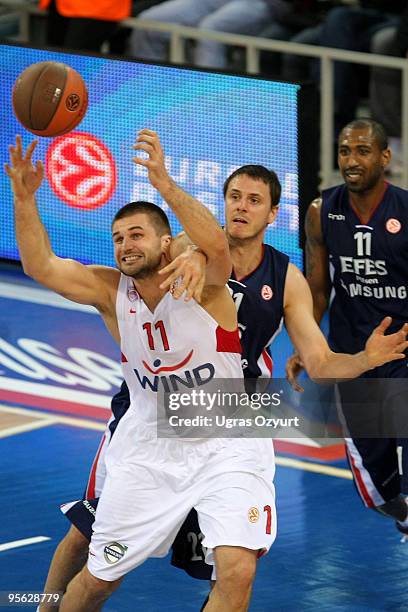 Linas Kleiza, #11 of Olympiacos Piraeus competes with and Bostjan Nachbar, #21 of Efes Pilsen Istanbul during the Euroleague Basketball Regular...