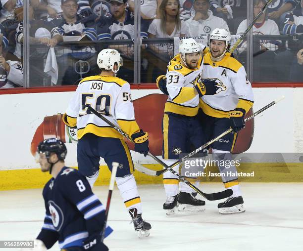 Roman Josi and Viktor Arvidsson of the Nashville Predators congratulate teammate Filip Forsberg on his second goal against the Winnipeg Jets in Game...