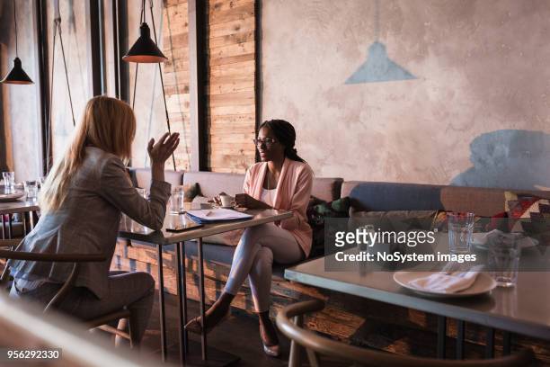 zwei geschäftsfrauen kaffeetrinken bruch in der high-end-restaurant - lunch meeting stock-fotos und bilder