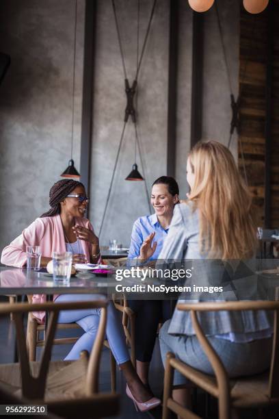 three businesswomen having meeting and business lunch at high-end restaurant - women meeting lunch stock pictures, royalty-free photos & images