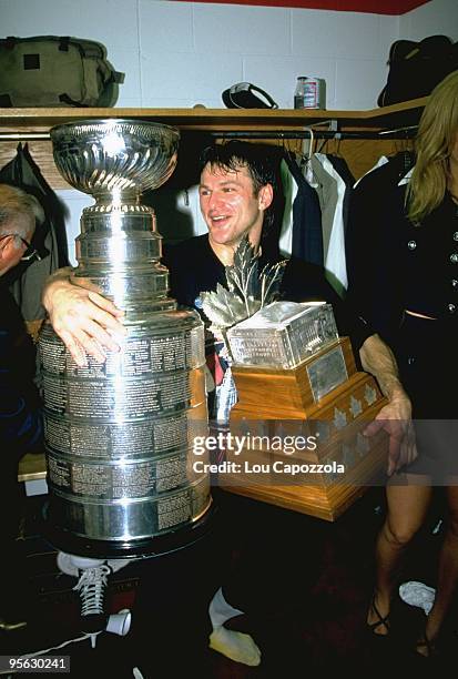 New Jersey Devils Claude Lemieux victorious in locker room with Stanley Cup trophy and Conn Smythe trophy after winning Game 4 and series vs Detroit...