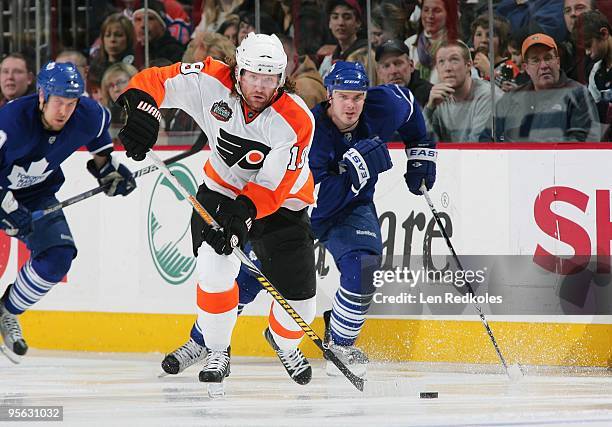 Scott Hartnell of the Philadelphia Flyers skates the puck past Ian White of the Toronto Maple Leafs on January 6, 2010 at the Wachovia Center in...