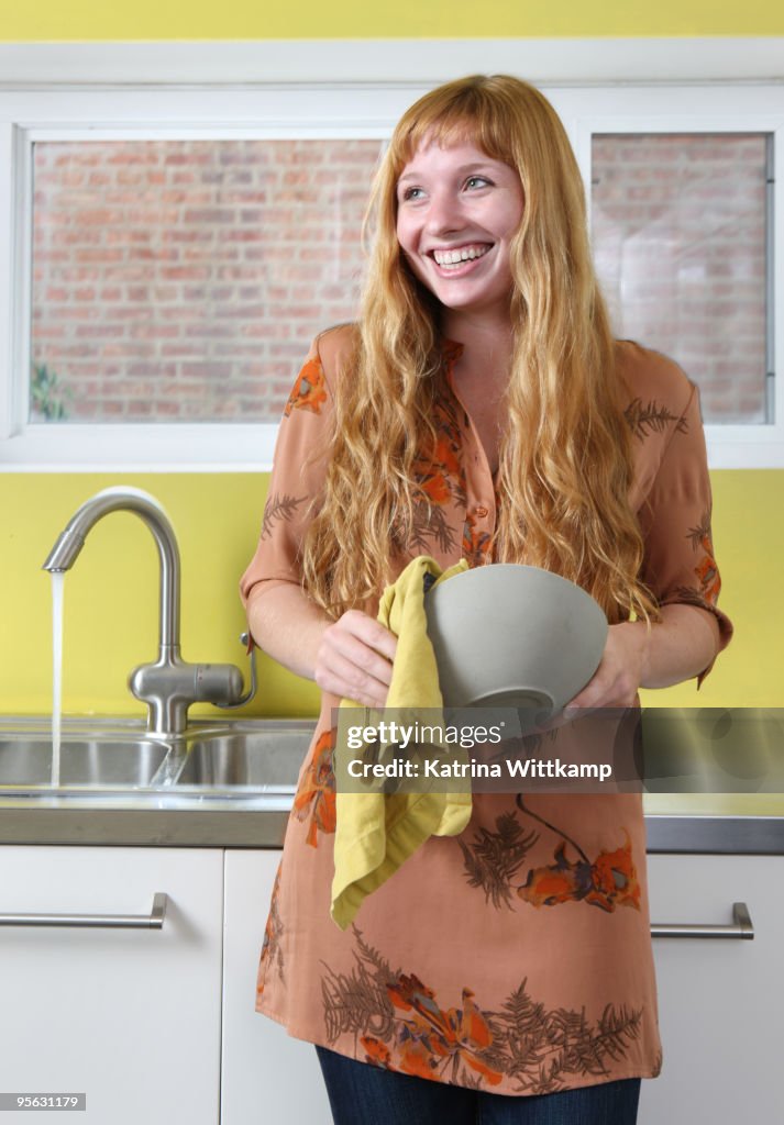 Woman drying bowl with towel.