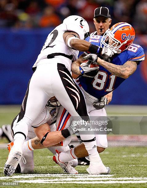 Dorian Davis of the Cincinnati Bearcats grabs the facemask of Aaron Hernandez of the Florida Gators during the Allstate Sugar Bowl at the Louisana...